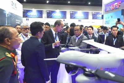 Mohamed Khaled (empat, kiri) melihat replika dron yang dipamerkan di reruai Mindef selepas merasmikan Pavillion Kementerian Pertahanan sempena DSA dan NATSEC Asia 2026 di MITEC pada Isnin. Foto Bernama