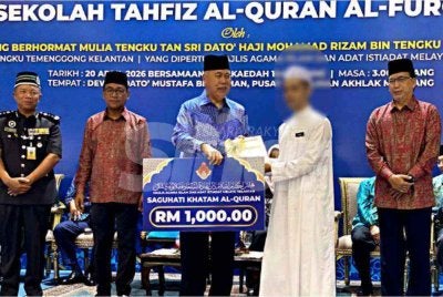 Tengku Mohamad Rizam (tiga dari kiri) menyampaikan saguhati khatam al-Quran kepada salah seorang hafiz al-Quran pada Majlis Khatam Perdana Hafazan Al-Quran Sekolah Tahfiz Al-Quran Al-Furqan di Pusat Pemulihan Akhlak Machang pada Isnin. Foto SINAR HARIAN/HAZELEN LIANA KAMARUDIN