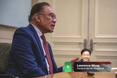 Anwar ketika mengadakan perbualan telefon dengan Perdana Menteri Singapura, Lawrence Wong. Foto FB Anwar Ibrahim