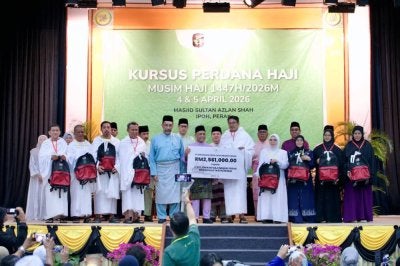 Saarani (tengah) menyerahkan replika cek sumbangan haji kepada wakil jemaah sempena Program Kursus Perdana Haji Musim Haji 1447 H / 2026 M di Masjid Sultan Azlan Shah di sini baru-baru ini.