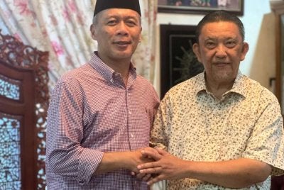 Zulkarnain (kiri) bersalaman dengan Ariss ( kanan) yang kembali menyertai UMNO.