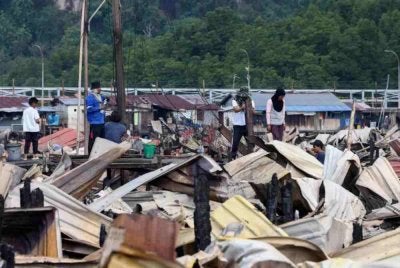 Beberapa penduduk mencari sisa-sisa barangan yang masih boleh digunakan selepas kediaman mereka musnah dalam kebakaran besar di Kampung Bahagia awal pagi Ahad. Foto Bernama