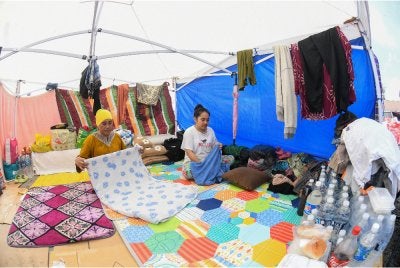Dambung Norin, 55, (kiri) bersama anaknya Rizma Baharin Nasiron, 34, mengemas khemah di kawasan lapang yang dijadikan tempat tinggal sementara selepas rumah mereka musnah dalam kebakaran Ahad lalu ketika tinjauan di Kampung Bahagia, pada Selasa. Foto Bernama