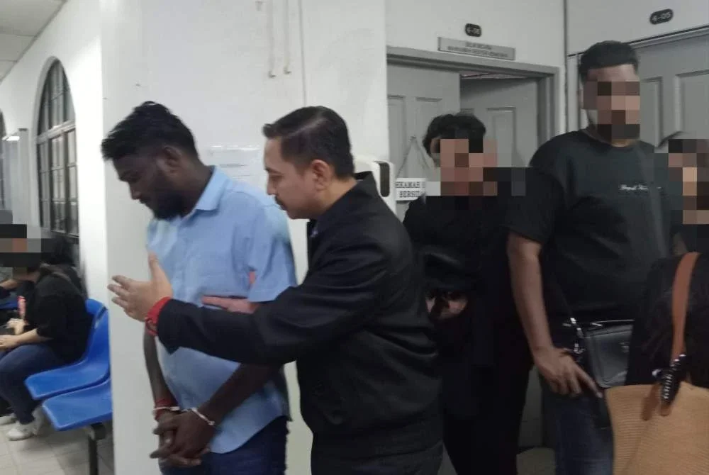 Dhivan (kiri) dihadapkan ke Mahkamah Sesyen Johor Bahru atas pertuduhan memberi rasuah kepada anggota URB IPD Segamat tahun lalu.