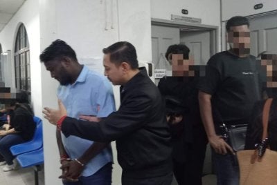 Dhivan (kiri) dihadapkan ke Mahkamah Sesyen Johor Bahru atas pertuduhan memberi rasuah kepada anggota URB IPD Segamat tahun lalu.