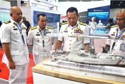 Mohd Rosli (dua dari kanan) melihat replika kapal induk MPMS yang dijangka akan diterima Maritim Malaysia pada tahun hadapan.