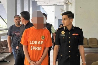 Suspek dibawa pegawai SPRM ke Mahkamah Majistret Seremban untuk permohonan reman. Foto SPRM