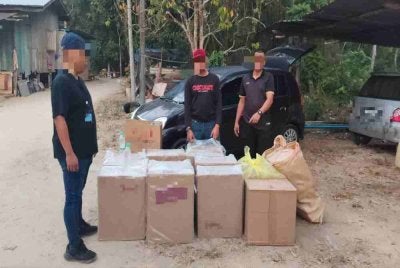 Kegiatan menyimpan dan menjual rokok tidak bercukai serta beras dipercayai diseludup dari Thailand terbongkar selepas dua lelaki tempatan diberkas dalam serbuan khas di Kampung Bukit Bidang, Selising, Pasir Puteh awal pagi Rabu. Foto: PDRM
