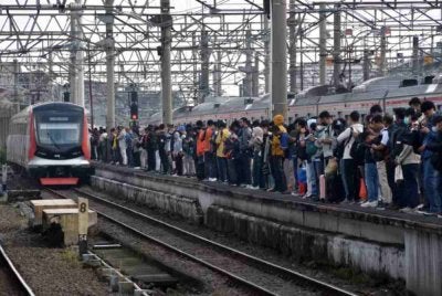 Penduduk Indonesia menunggu ketibaan tren bagi pelbagai tujuan termasuk ke tempat kerja. Foto Agensi