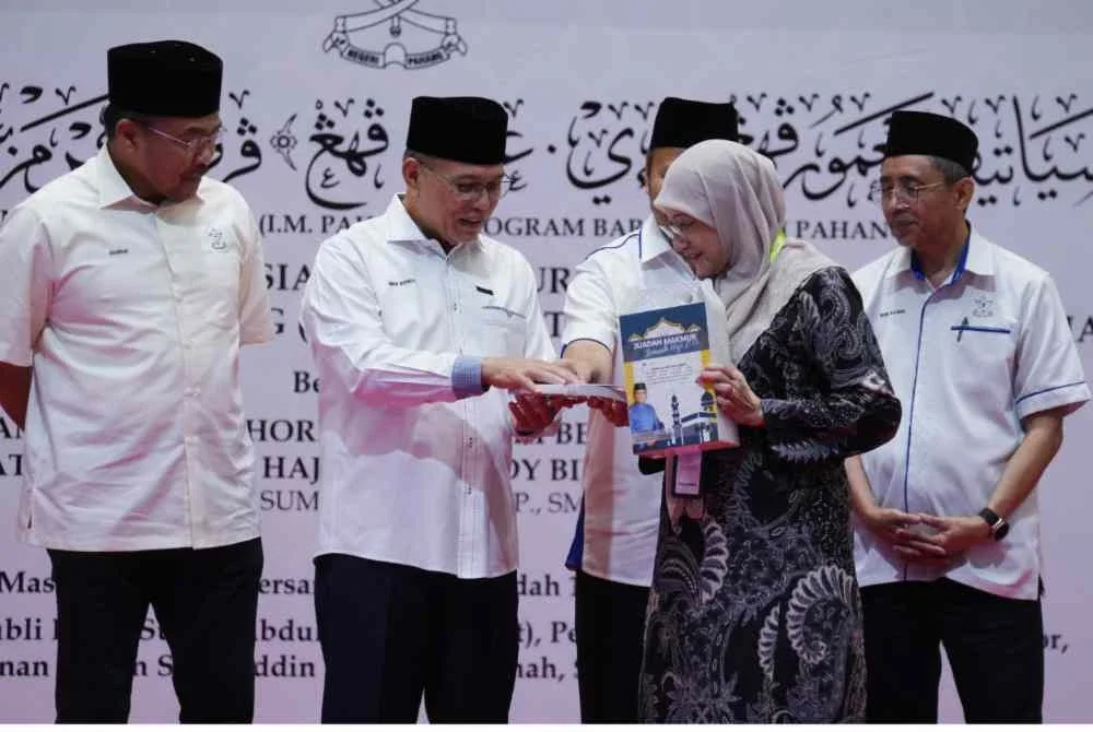 Wan Rosdy (dua dari kiri) menyampaikan inisiatif kepada salah seorang penerima di Bangunan Sultan Salahuddin Abdul Aziz Shah di sini pada Khamis.