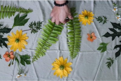 Misbaahussalam menyusun daun dan bunga untuk menghasilkan corak dalam pembuatan produk berasaskan teknik eco-print di kediamannya di Benut. Foto Bernama 