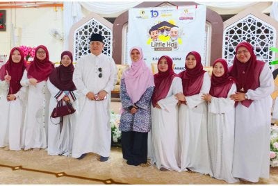 Marhamah (tengah) bergambar bersama petugas semasa menyantuni pelajar tadika yang menyertai kursus haji cilik di Masjid Jamek Muhammadi, Kota Bharu pada Khamis.Foto:SINAR HARIAN/HAZELEN LIANA KAMARUDIN