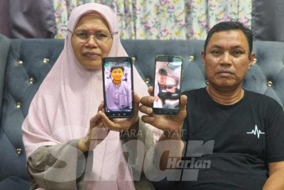 Jamaluddin dan Siti Roslina menunjukkan gambar kenangan arwah anaknya itu.