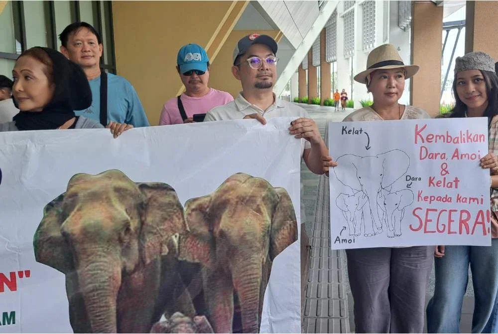 Peserta demonstrasi membawa sepanduk bantahan.