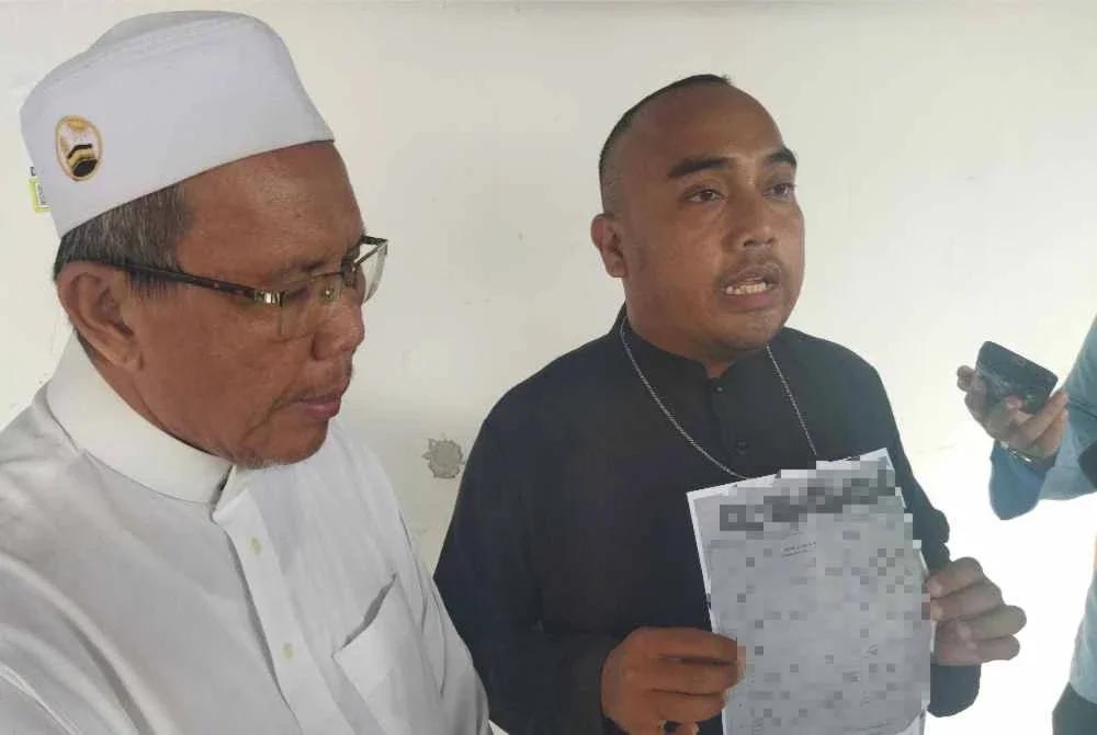 Mohd Firdaus (kanan) bersama Abdullah menunjukkan dokumen minit mesyuarat yang tular di media sosial.