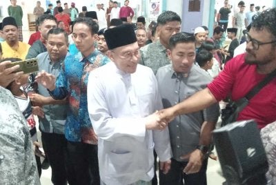 Anwar bersalaman dengan orang ramai selepas menunaikan solat Jumaat di Masjid Bandar Permas Jaya, Johor Bahru pada Jumaat.