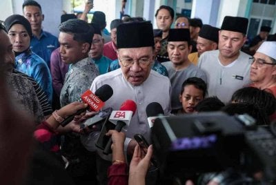 Perdana Menteri, Datuk Seri Anwar Ibrahim (tengah) bercakap kepada pemberita selepas menunaikan solat Jumaat di Masjid Bandar Permas Jaya hari ini. Foto Bernama 