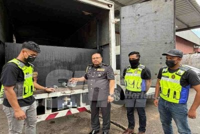 Mohd Hazimin (tiga dari kanan) menunjukkan tangki tambahan pada lori tiga tan disyaki bagi tujuan penyelewengan subsidi. 
