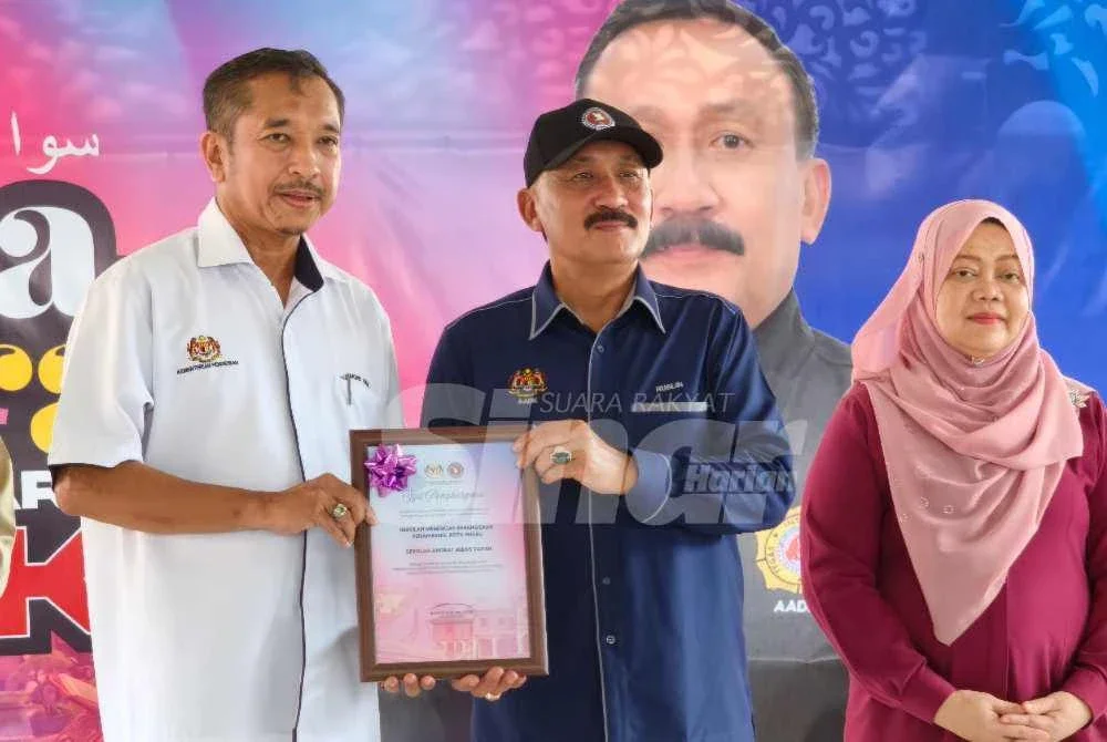 Ruslin (tengah) menyampaikan sijil kepada penerima semasa merasmikan Program Sua Mesra AADK di SMK Penambang di Kota Bharu pada Sabtu.Foto:SINAR HARIAN/HAZELEN LIANA KAMARUDIN