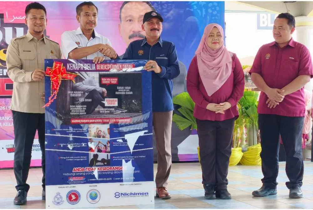 Ruslin (tiga dari kanan) menyampaikan
penyerahan sekolah angkat bebas dadah pada Program Sua Mesra AADK di SMK Penambang di Kota Bharu pada Sabtu. Foto:SINAR HARIAN/HAZELEN LIANA KAMARUDIN