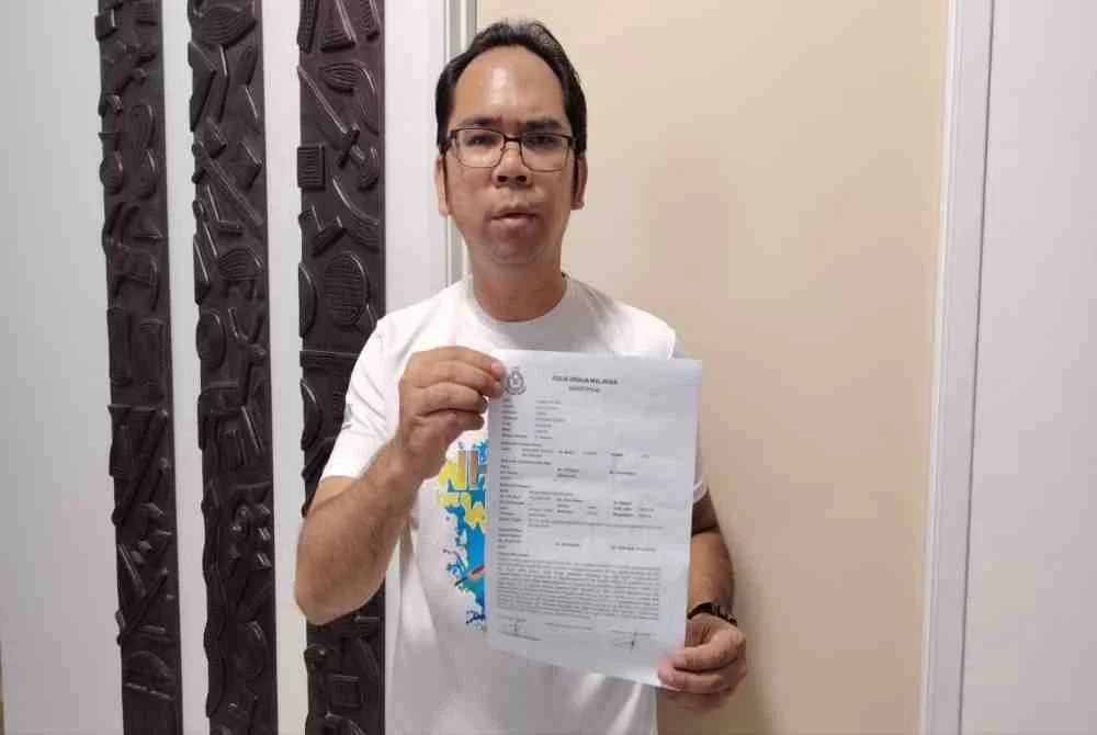 Mohd Firdaus menunjukkan laporan polis yang dibuat di Ibu Pejabat Polis Daerah Kuala Muda.