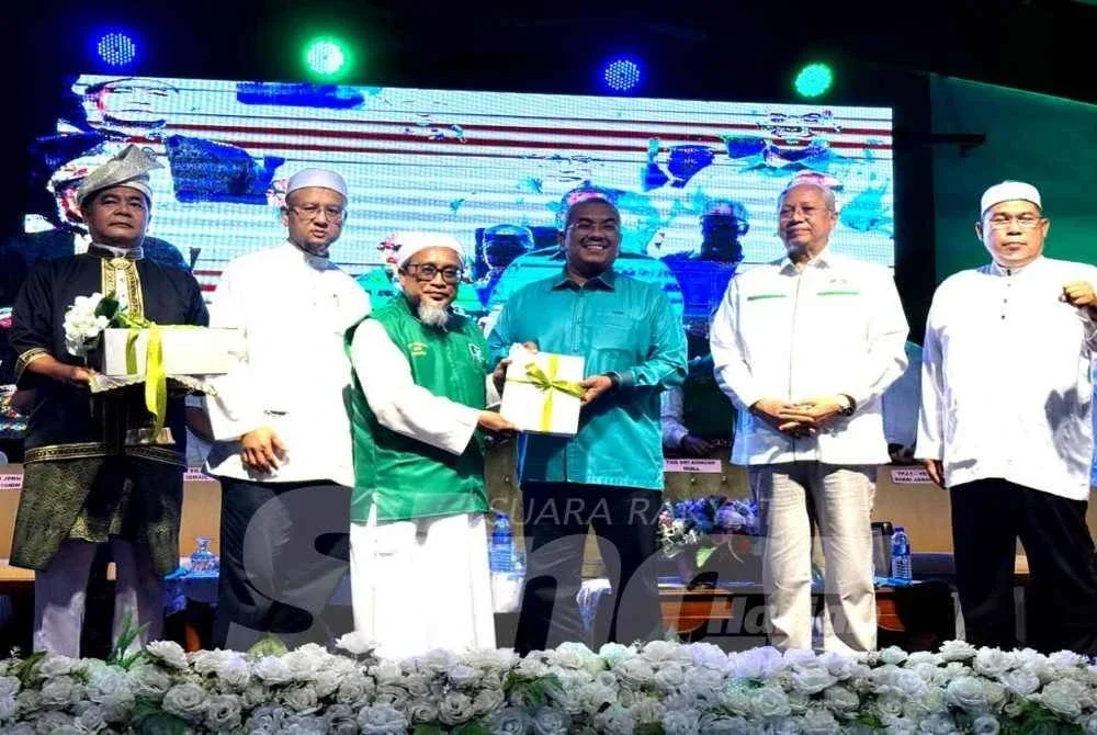 Sanusi (tengah) menerima borang pendaftaran ahli dan pembukaan cawangan Pas di Melaka diserahkan Zulkifli pada majlis berlangsung Sabtu.
