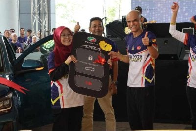 Shazeli (kanan) menyampaikan hadiah cabutan bertuah kepada peserta program Larian Diraja Selangor Bersama PDRM dan Masyarakat di Elmina, Shah Alam pada Ahad.