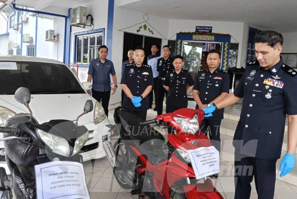 Hadzrat Hussin (kanan) menunjukkan antara motosikal yang dirampas dipercayai digunakan dalam kegiatan samun dan curi kenderaan oleh Geng Kuyai.