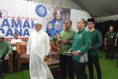Sanusi (tiga dari kanan) dan Mahfodz (kiri) melancarkan jentera pilihan raya Pas dalam Program Ceramah Perdana PN Johor di Pusat Komuniti Pas Muar, Parit Tarom, Muar.