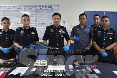 Hadzrat Hussien (tengah) menunjukkan parang yang digunakan dalam beberapa kejadian samun kedai serbaneka 24 jam.