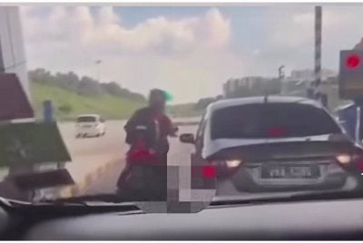 Tangkap layar video tular memaparkan seorang penunggang motosikal menendang sebuah kereta di Plaza Tol Kajang pada Ahad.