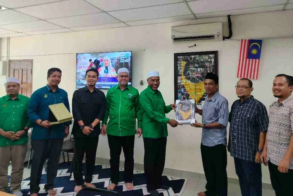 Sayed Mohd Hesham (tiga dari kanan) menyampaikan cenderahati kepada Idris (empat dari kanan) selepas menerima kunjungan delegasi Pas Perak di Rumah Media Perak, pada Selasa.