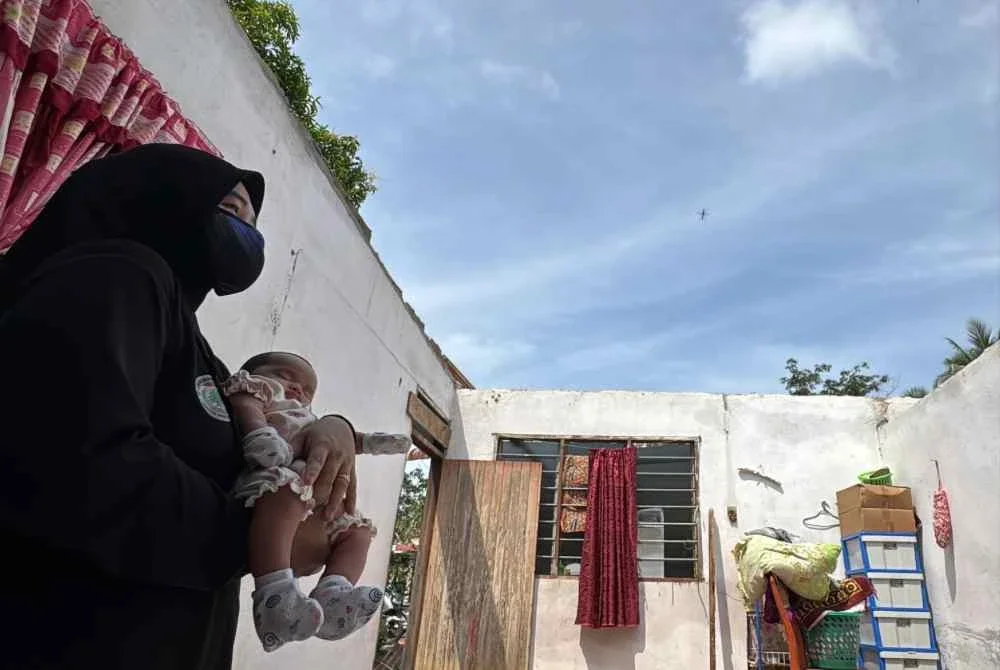 Fatin Nadirah menunjukkan bumbung rumah ibu mentuanya yang rosak akibat ribut.