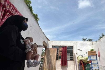 Fatin Nadirah menunjukkan bumbung rumah ibu mentuanya yang rosak akibat ribut.