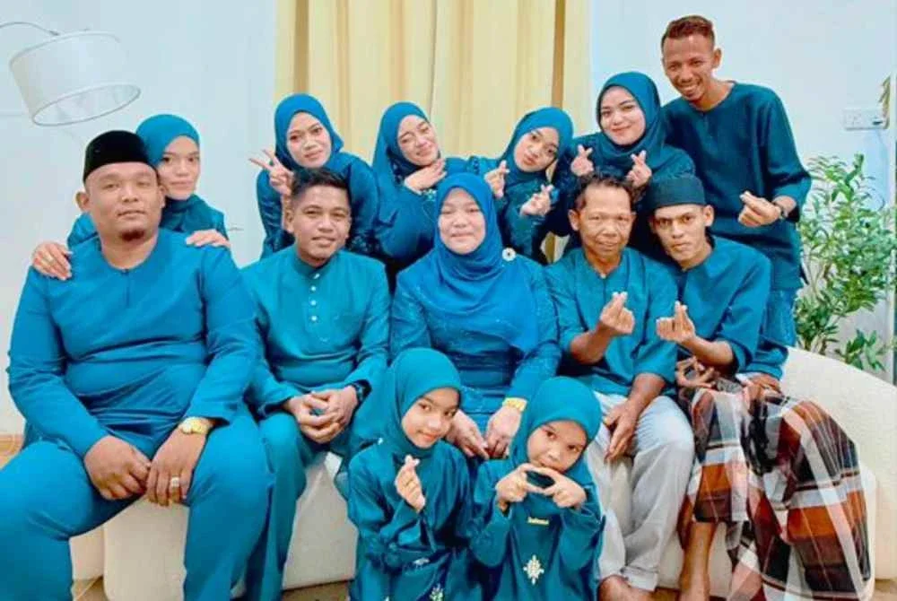 Nik Muhammad Hazrul Akma (duduk dari kanan) manakala Nik Nur Ismaizzati (belakang, dua dari kiri) bersama ahli keluarga merakam gambar semasa Hari Raya Aidilfitri yang lalu.