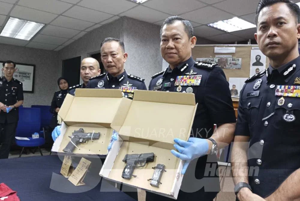 Ab Rahaman (dua dari kanan) menunjukkan pistol yang digunakan semasa sesi latihan menembak di Kota Tinggi.