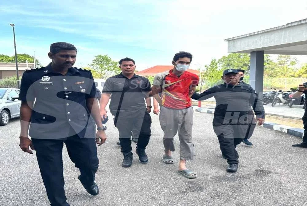 Mohd Azwan (dua dari kanan) dikawal ketat polis ketika tiba di pekarangan Mahkamah Majistret Kota Bharu pada Khamis.
