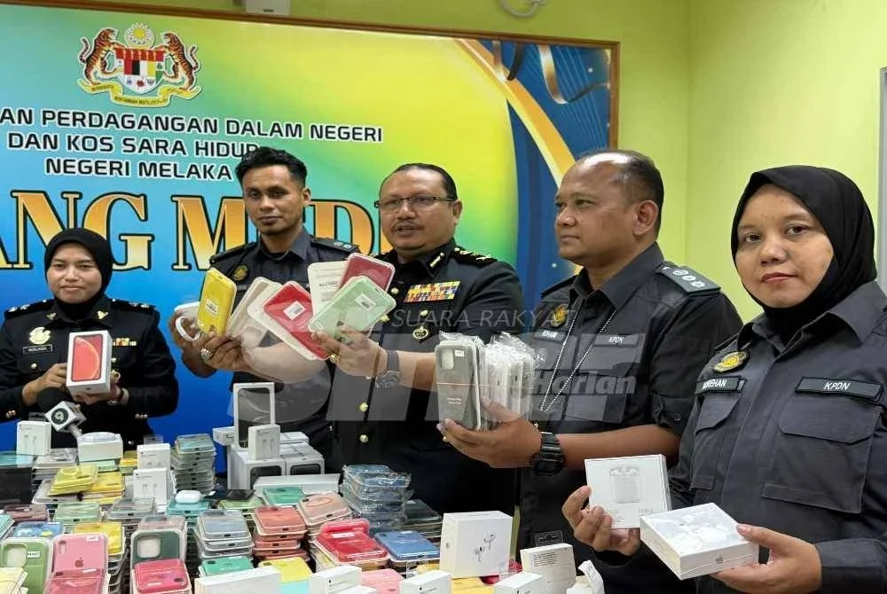 Mohd Hazimin (tengah) menunjukkan rampasan aksesori iPhone tiruan yang dirampas.
