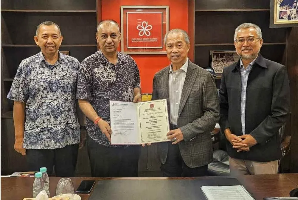 Mohd Yazid (dua dari kiri) menerima Watikah pelantikan sebagai ketua BPN Bersatu Pahang daripada Muhyiddin.