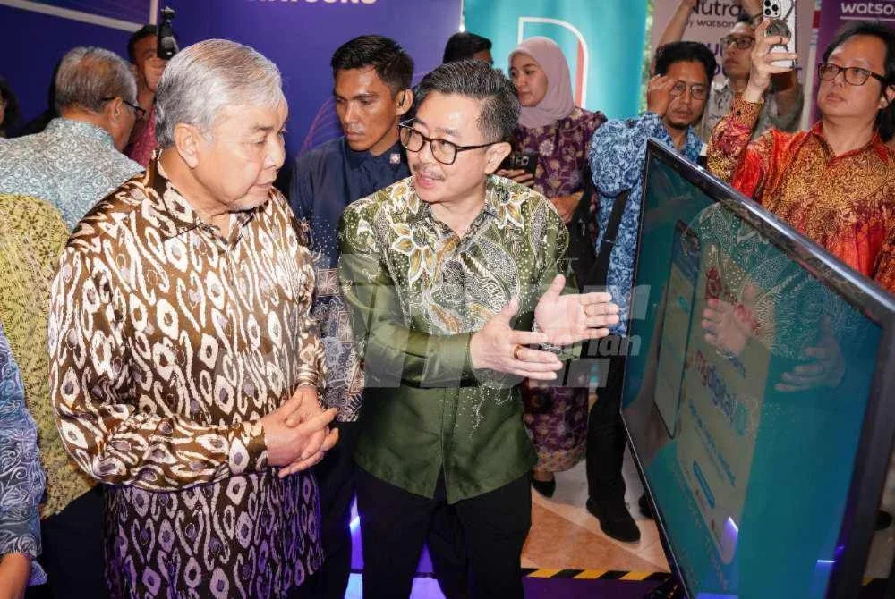Ahmad Zahid (kiri) melawat melawat dan melihat tapak pameran pada majlis Powering Trusted Access Across Malaysia Digital Ecosystem yang diadakan pada Khamis. Foto Sinar Harian