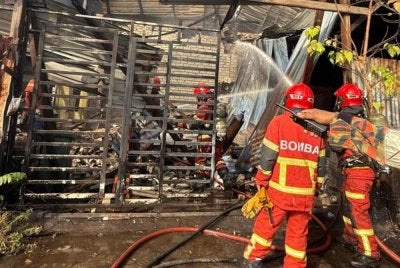 Anggota bomba sedang melakukan kerja-kerja pemadaman api di sebuah bengkel membaiki lori di Lorong Bukit Setongkol di sini musnah dalam kebakaran pagi Khamis. FOTO: Bomba Pahang