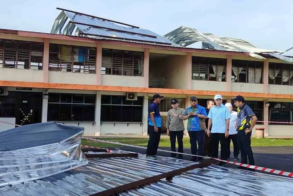 Mohammad Dziauddin (dua dari kiri) bersama Reezal (tiga dari kiri) melawat SMK Datuk Haji Abdul Kadir yang mengalami kerosakan teruk selepas dipukul ribut.