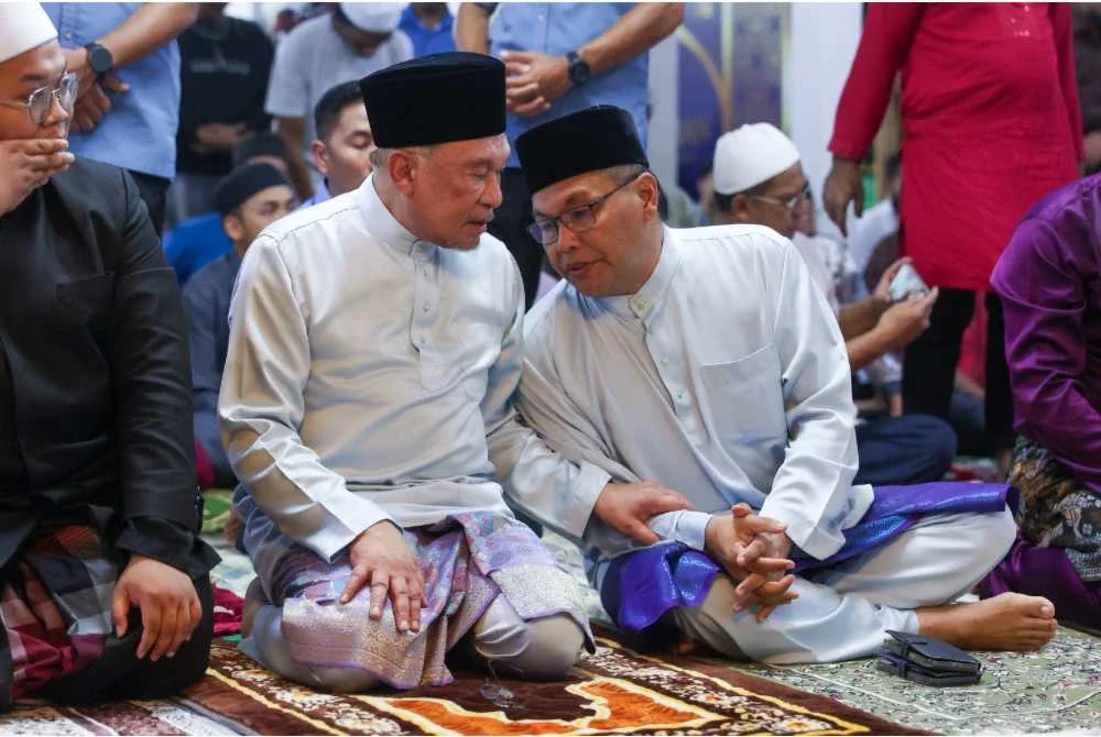 Anwar (kiri) ketika menunaikan solat Jumaat di Masjid Nurul Iman Rawang. Foto Bernama
