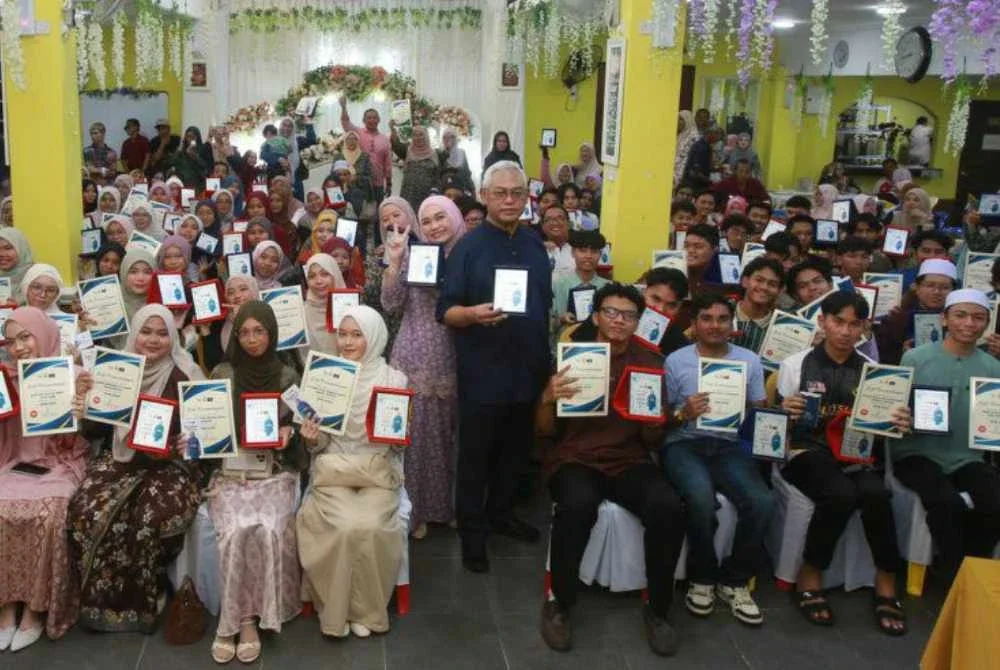 Nurul Syazwani dan Timbalan Presiden Muafakat Nasional, Tan Sri Noh Omar bergambar bersama pelajar cemerlang SPM 2025 di Kuala Selangor pada Jumaat.
