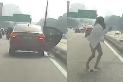 Tangkap layar video tular memaparkan seorang wanita terjun dari kereta pada Jumaat.