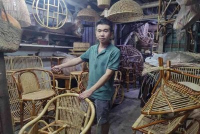 Poh Ping menunjukkan pelbagai barangan rotan yang dihasilkan di bengkelnya di Klang.