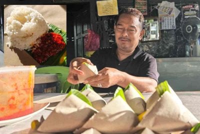 Anuar membungkus nasi lemak yang dijual 50 sen sebungkus.