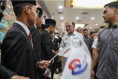 Anwar menyantuni para pelajar ketika hadir pada Majlis Sambutan 60 Tahun Majlis Amanah Rakyat (MARA) di Dewan Merdeka, Pusat Dagangan Dunia Kuala Lumpur, pada Ahad. Foto Bernama