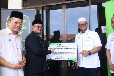 Mustakim (tengah) bersama Zulkifli (kanan) dan Kadi Pejabat Daerah Besut, Ahmad Azhar Harun ketika menyempurnakan perasmian Surau Al-Hajj di Taman Koperat Putera, Kampung Seberang, Besut pada Ahad.