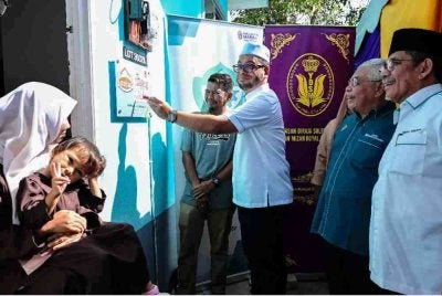 Zulkifli (tengah) menyempurnakan gimik perasmian pada Majlis Penyerahan Rumah Bina Baharu Program Sinar Lestari Yayasan Pembangunan Ekonomi Islam Malaysia (YaPEIM) - Yayasan DiRaja Sultan Mizan di Kampung Gong Tok Dor Dalam, pada Ahad. Foto Bernama